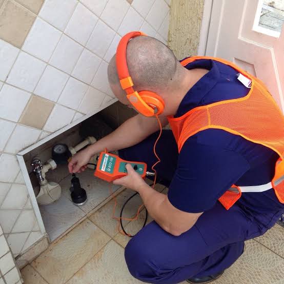 Técnico da SOS Caça Vazamentos utilizando equipamento eletrônico para localizar vazamento